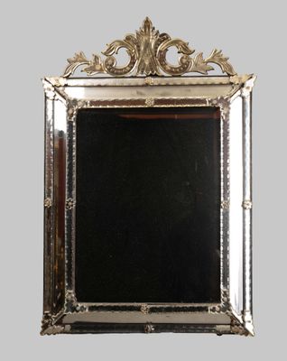 an image of a silver framed mirror on a gray wall