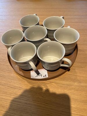 six tasses posées sur une assiette sur la table