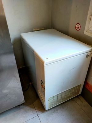 un petit réfrigérateur blanc dans un coin de la pièce