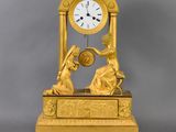 a gold clock that is sitting on top of a table