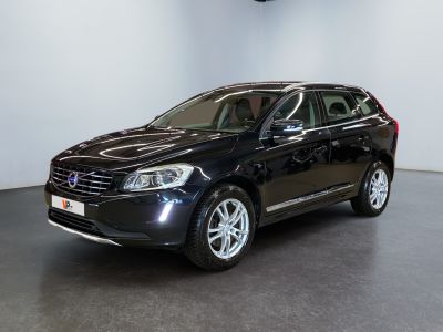 La voiture noire est garée dans une grande pièce au sol noir.