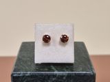 a close up of a pair of earrings sitting on top of a marble block