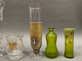 four different colored glass vases sitting on a table