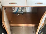 a small kitchen with a sink and a trash can