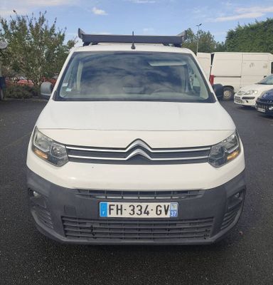 la camionnette blanche est garée dans un parking avec d'autres voitures