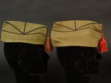 two hats with tassels on top of them on a mannequin head