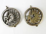 two silver and gold pendants with a bird in the center