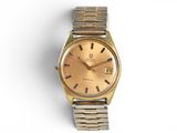 an image of a gold wrist watch on a white surface
