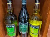 Trois bouteilles d'alcool sont posées sur une étagère dans un magasin.