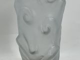 a glass vase with a face on it sitting on a table