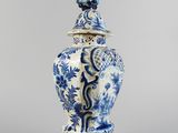 blue and white vase with a bird on top of it