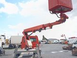 a red crane that is sitting in the middle of a parking lot