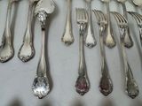 a lot of silver spoons and forks on the table
