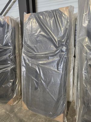 de nombreux meubles emballés dans du plastique dans un entrepôt