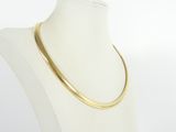 a white mannequin torso with a gold necklace on it