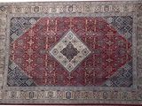 un tapis oriental orné d'un motif en losanges sur fond rouge