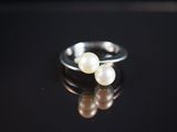 deux perles blanches reposent sur une surface noire