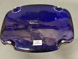 a blue glass bowl with gold trim and a label on it