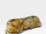 un gros plan d'une petite figurine d'animal posée sur une surface blanche