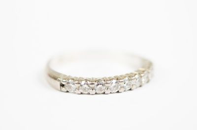 a close up of a diamond ring on a white surface