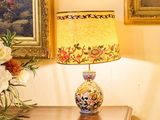 un vase de fleurs posé sur une table à côté d'une lampe