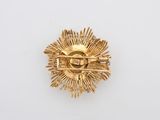 a close up of a gold pin with a star on it