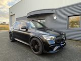 un SUV Mercedes noir garé devant un immeuble