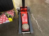 a red jack with a tire on it in a garage