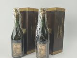 deux bouteilles de champagne posées l'une à côté de l'autre sur une surface blanche