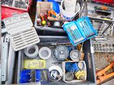 many different tools in a metal box on the ground