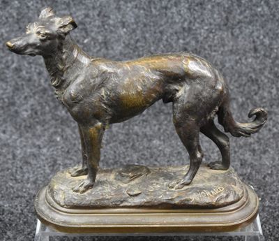 bronze statue of a dog on a wooden base on a black background