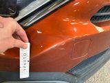a person that is holding a sticker on the front of a car