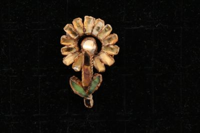 une image montrant un gros plan d'une broche posée sur une surface noire