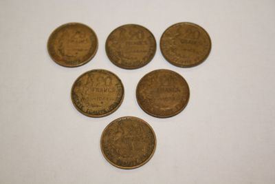 six coins are arranged in a triangle on a white surface