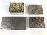 four pieces of metal are sitting on top of a white surface