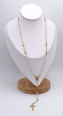 un gros plan d'un collier porté par un mannequin, orné d'une croix
