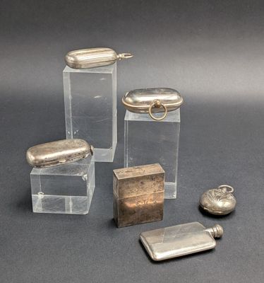 trois petits récipients en verre avec des couvercles argentés et un briquet posés sur une table