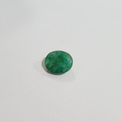 a close up of a green jade stone on a white surface