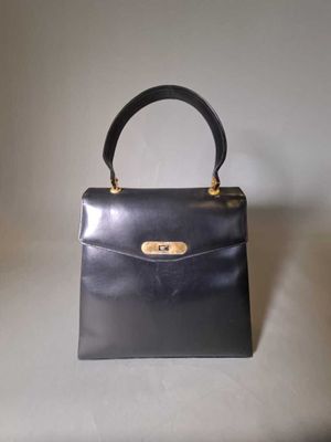 sac à main vintage en cuir noir avec des finitions dorées