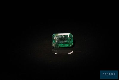 une pierre verte couleur émeraude sur un fond noir
