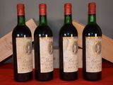 three bottles of red wine sit on a table next to a wooden box