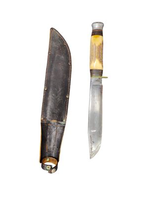 a knife that is laying next to a knife sheath