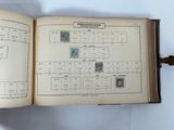 an open book with stamps on it sitting on a table