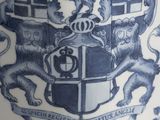 a blue and white vase with a coat of arms on it