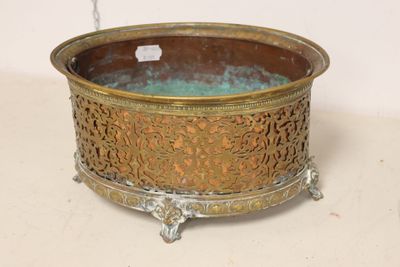 a large metal bowl with a handle on a table