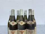 quatre bouteilles de vin sont alignées sur un plan de travail en marbre