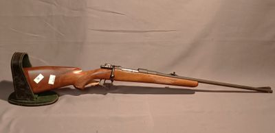 un vieux fusil avec un canon en bois et une poignée en métal