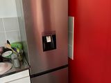 a stainless steel refrigerator in a kitchen with a red wall
