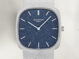 une montre en argent avec un cadran bleu et un bracelet blanc
