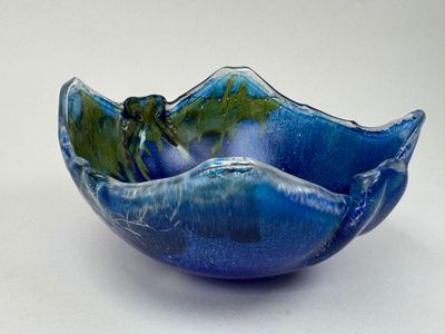 a blue bowl with a green leaf inside of it